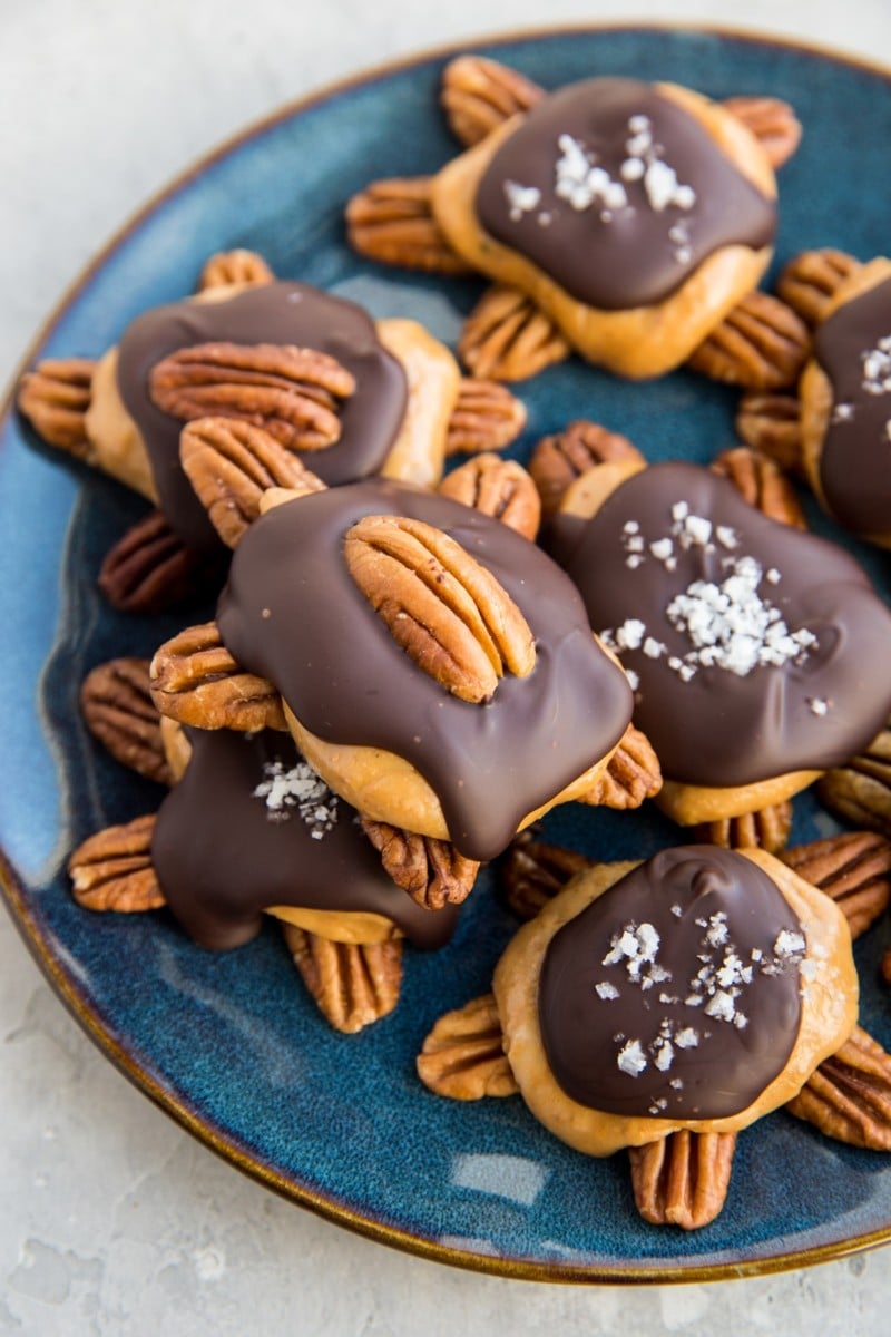 Pecan turtle candy on a blue plate, ready to serve