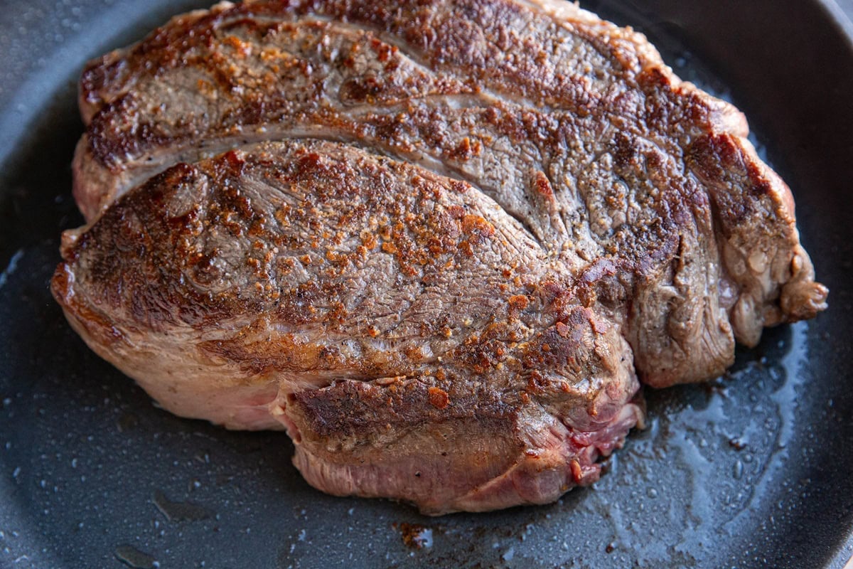 Seared chuck roast in a skillet.