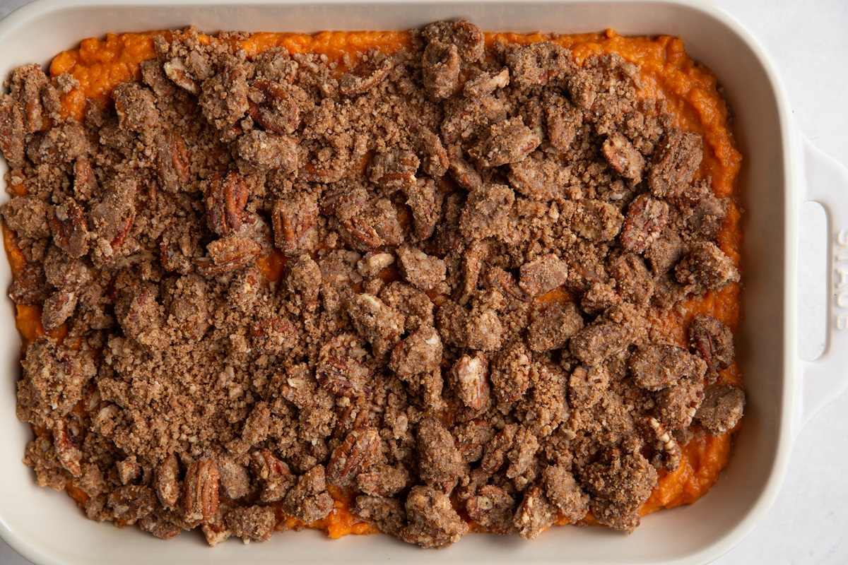 Mashed sweet potatoes topped with pecan crumb topping, ready to go into the oven.