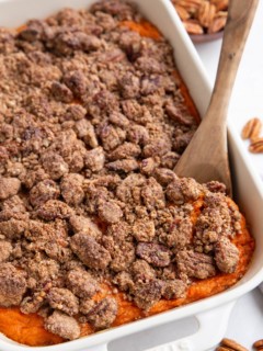 Large casserole dish of sweet potato casserole with pecan crumb topping.