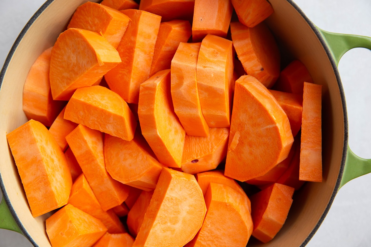 Chopped sweet potatoes in a large pot, ready to be boiled.