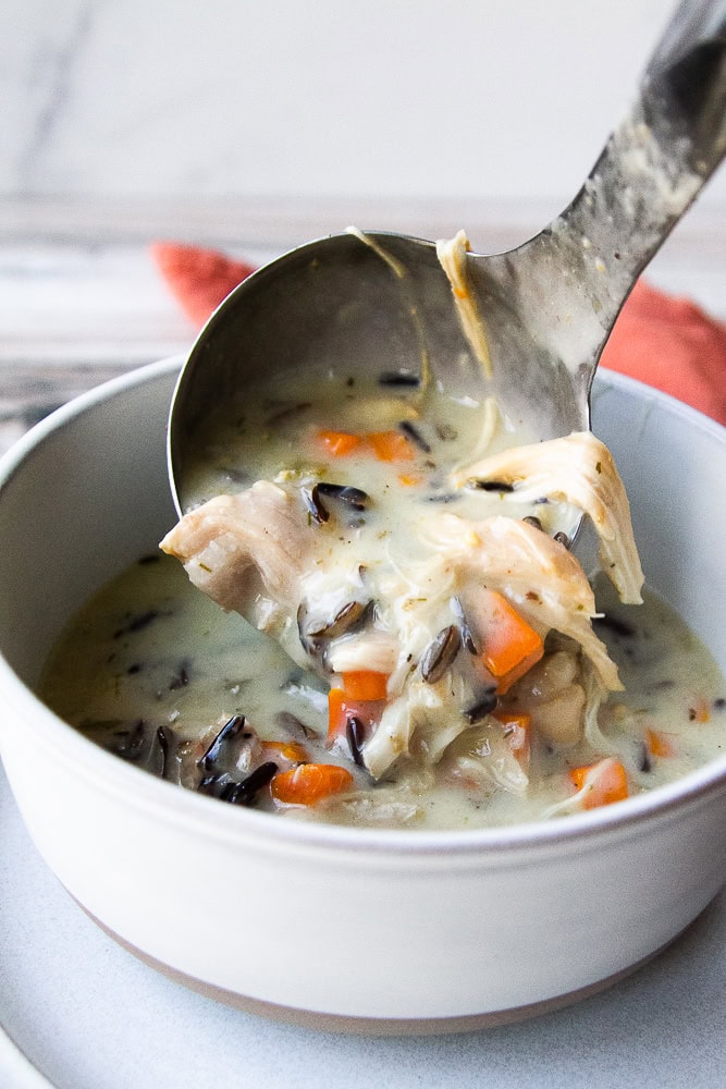 Creamy Chicken and Wild Rice Soup being poured into a bowl