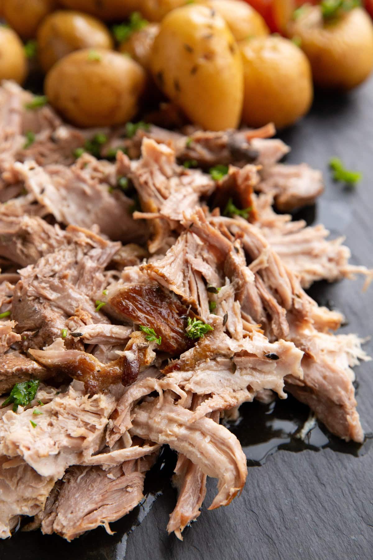 Shredded pork on a black serving platter.