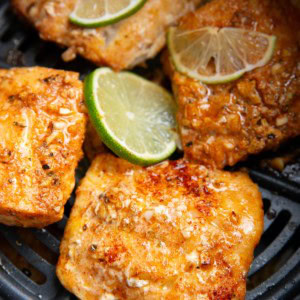 Four cod filets in an air fryer freshly air fried and ready to eat.