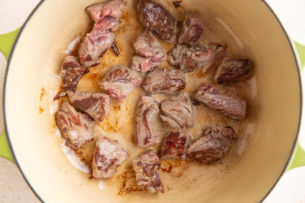 Beef stew meat searing in a Dutch oven.