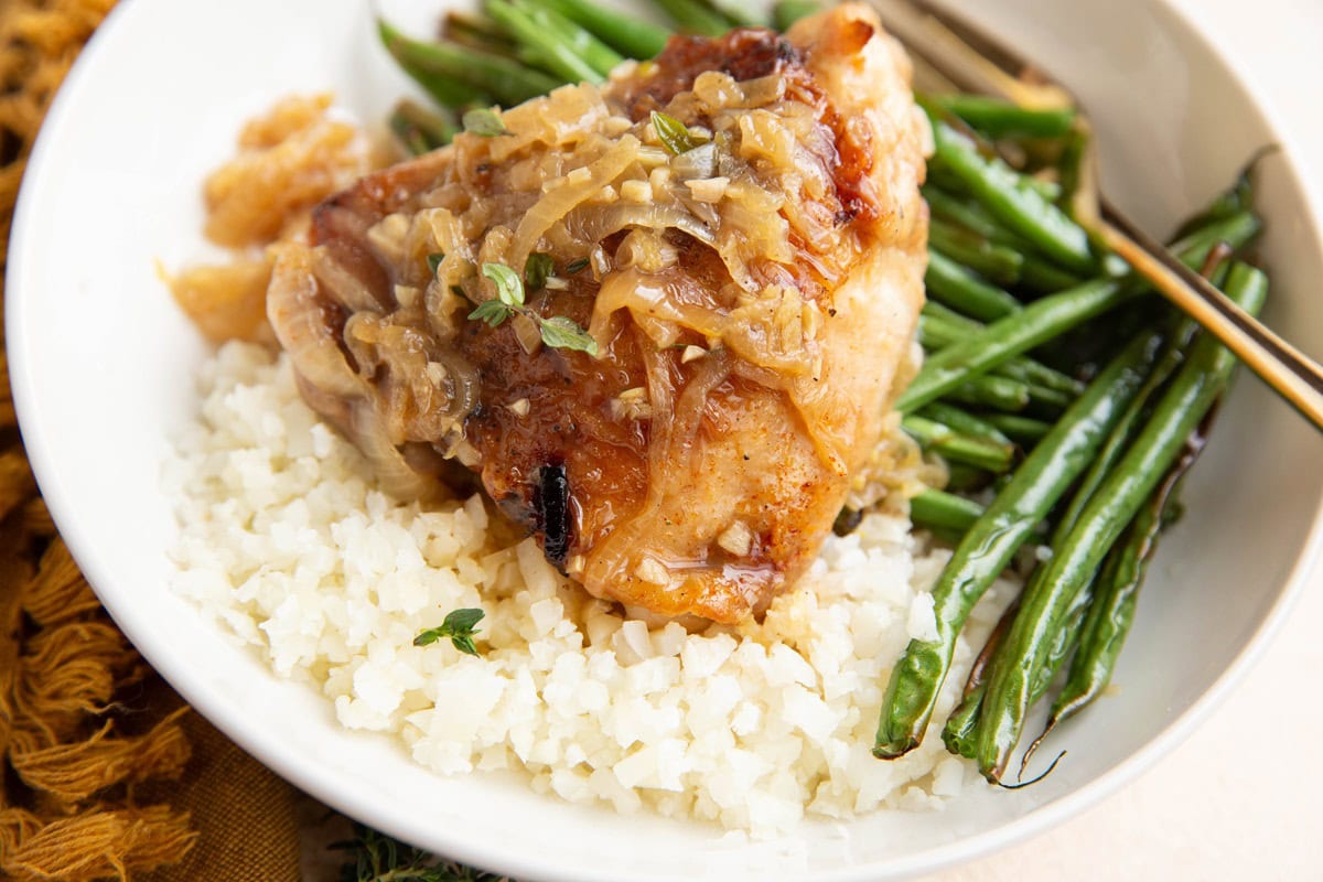 Chicken on top of cauliflower rice with green beans.