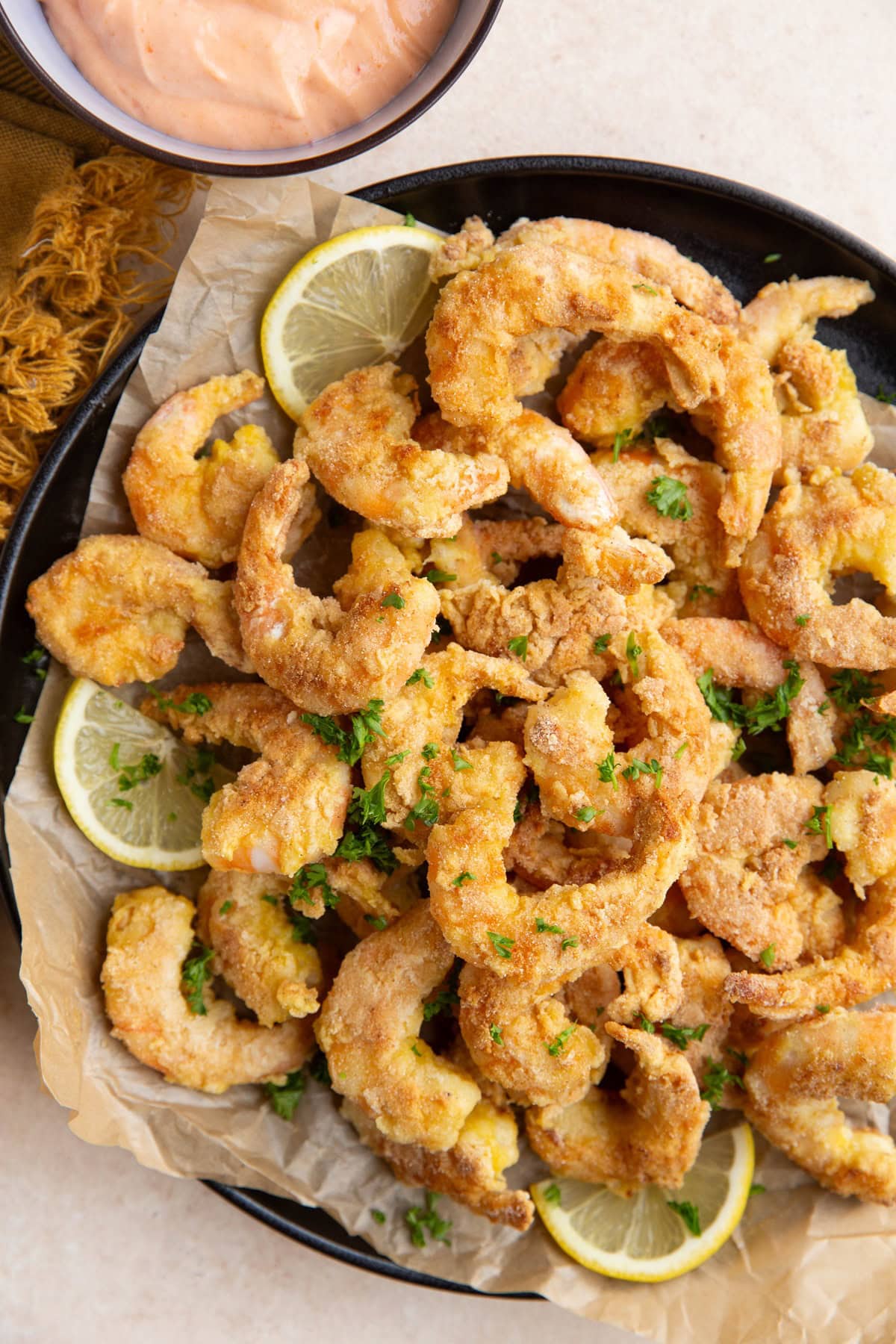 plate of pan-fried shrimp with bowl of bang bang sauce to the side.