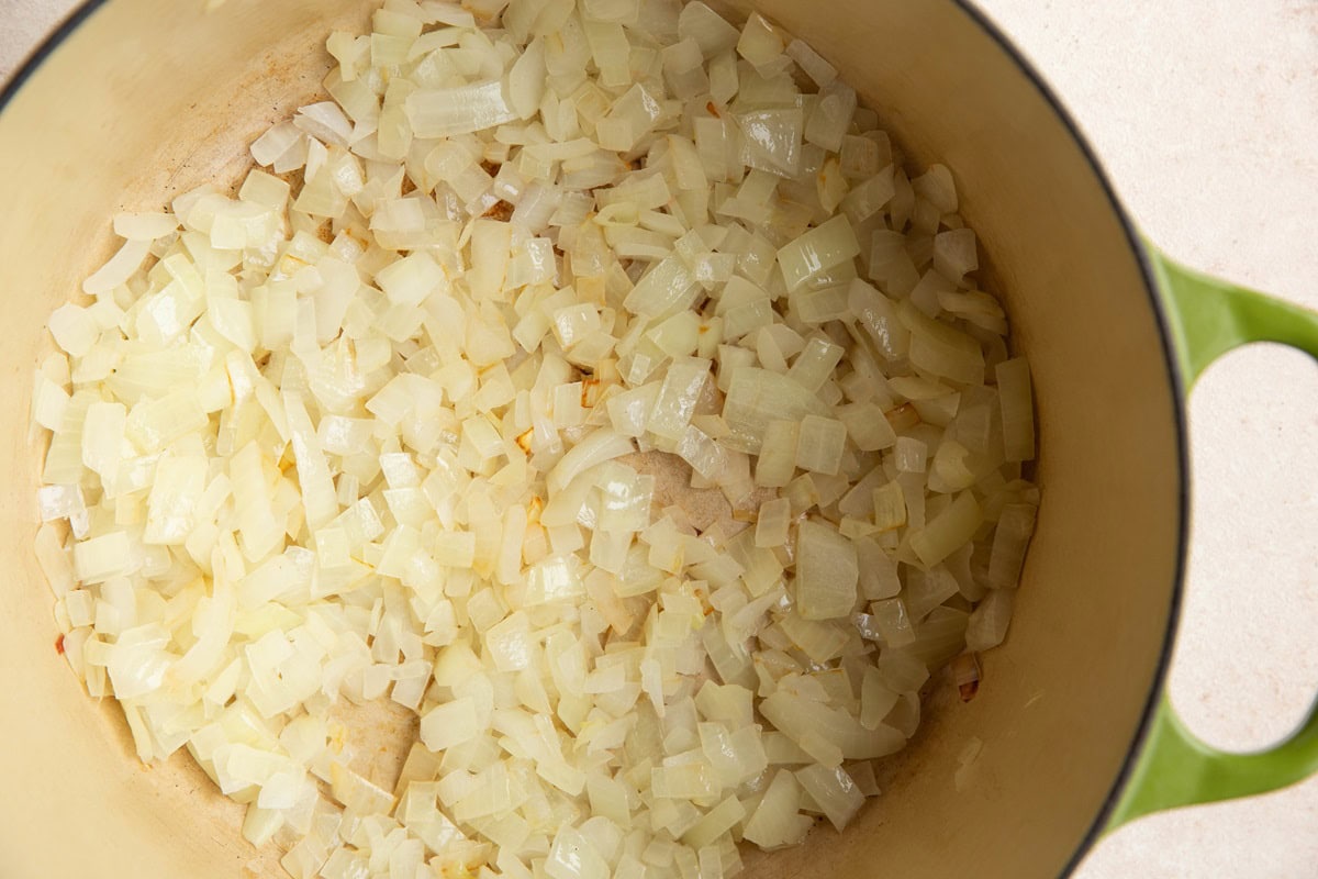 Onions sautéing in a large pot.