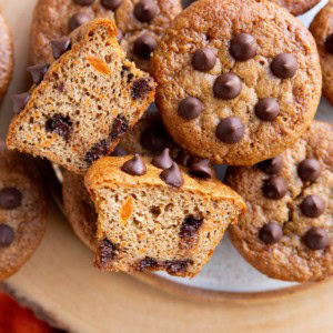 Plate of sweet potato muffins with one cut in half so you can see the inside.