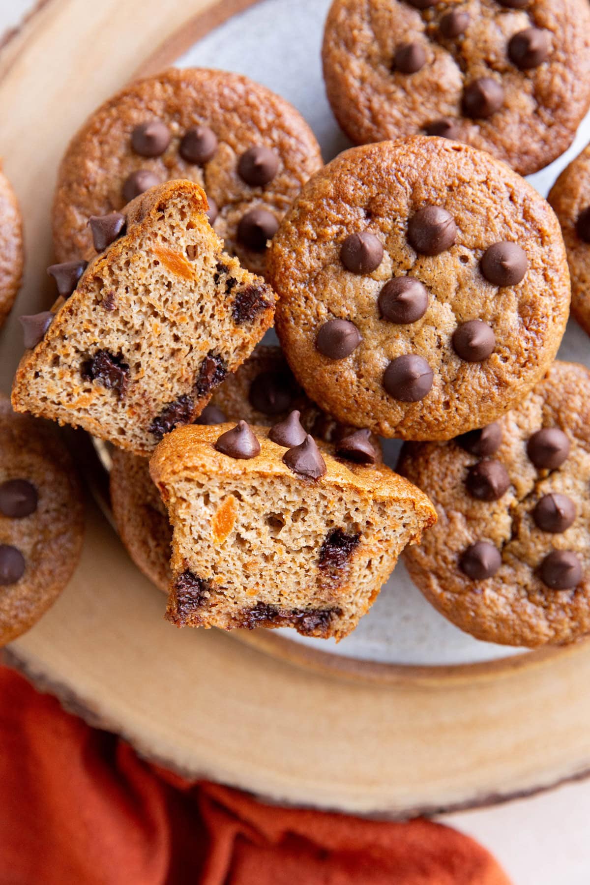 Plate of sweet potato muffins with one cut in half so you can see the inside.