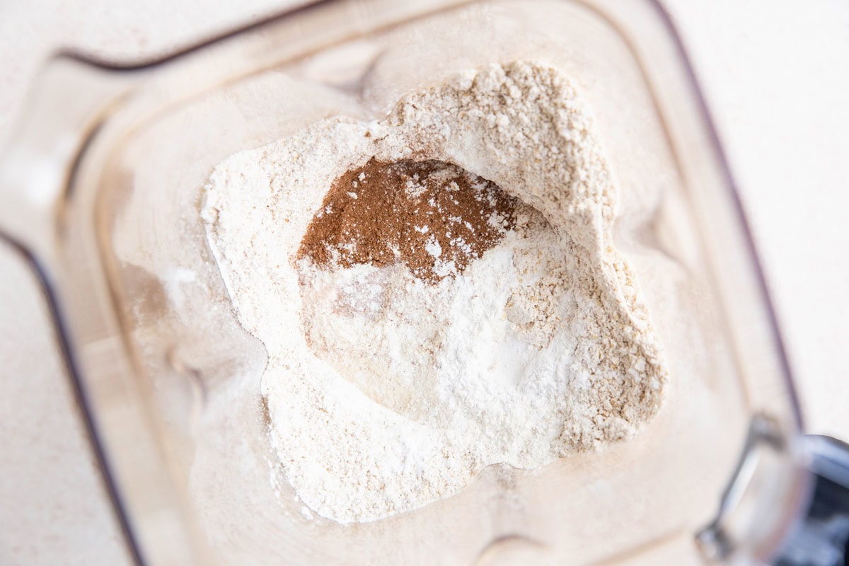 Blender with oat flour, cinnamon, baking powder and salt inside.