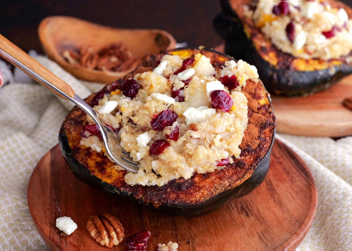 Fork taking a bite out of a stuffed acorn squash.