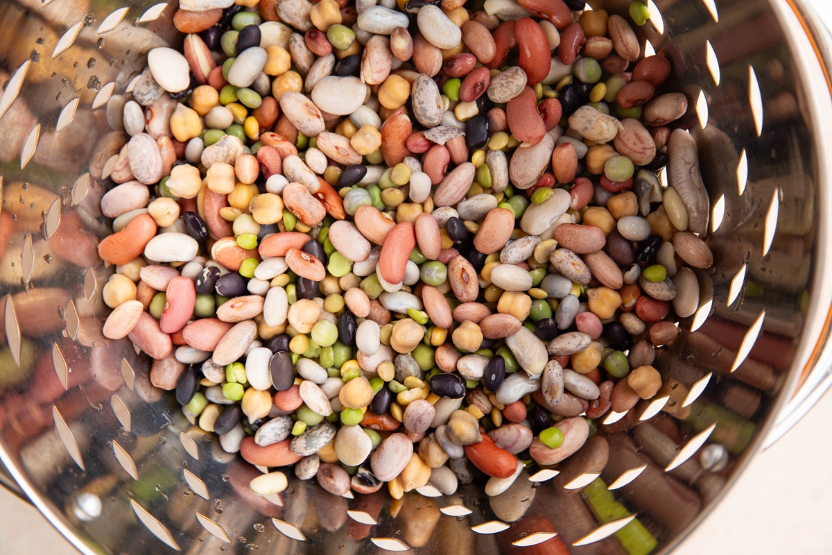 15 different kinds of beans in a colander, soaked and ready to be made into soup.