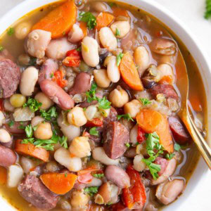 Teo bowls of sausage and bean soup. Closeup so you can see all the different types of beans.