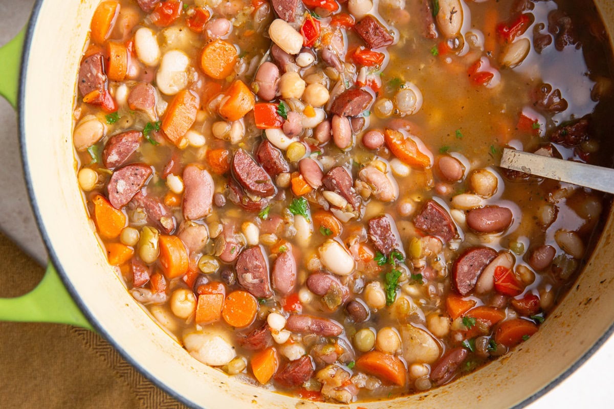 Big Dutch oven pot full of bean and sausage soup. Ready to eat.