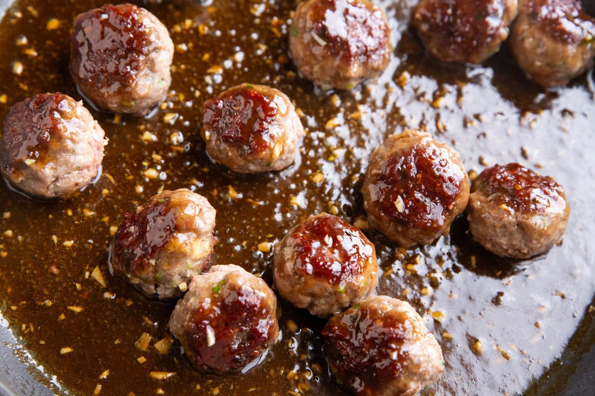 Skillet full of glazed meatballs.