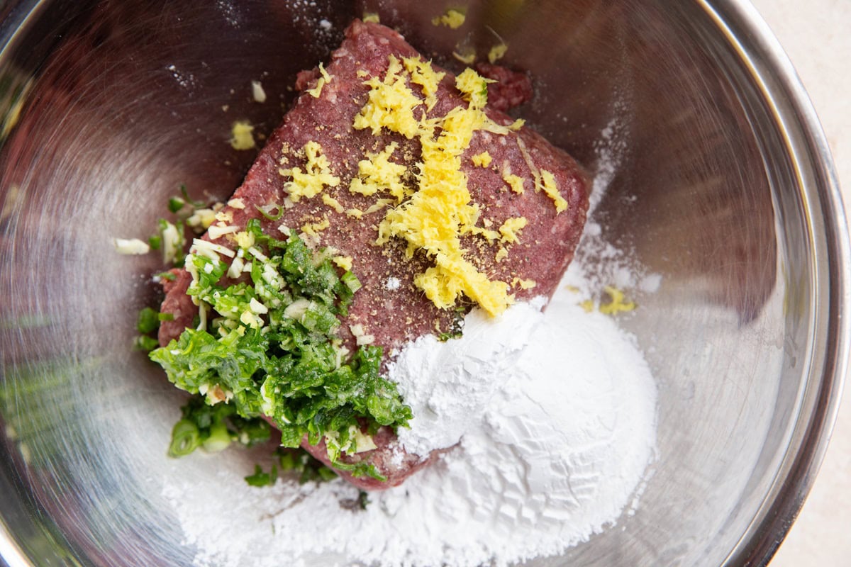 sesame garlic meatball ingredients in a stainless steel mixing bowl to make meatballs.