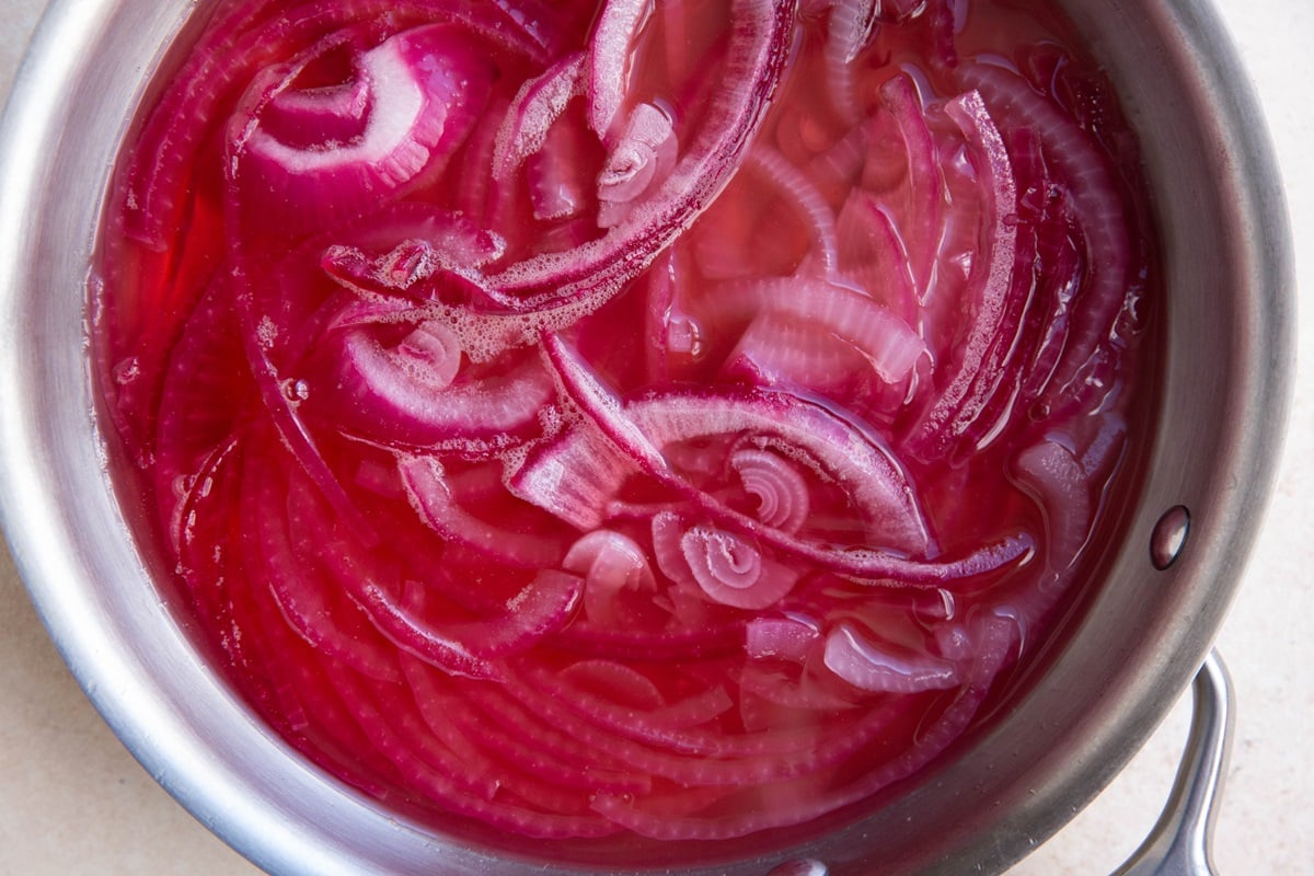 Saucepan with vinegar and sliced red onions.