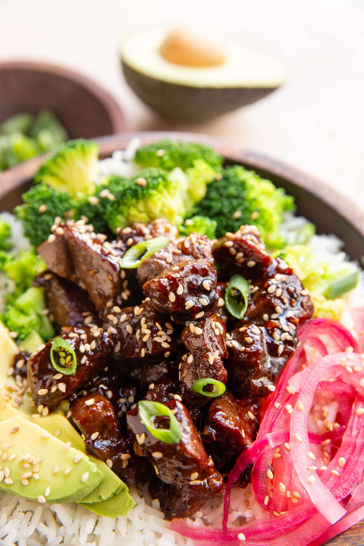 Close up image of sweet garlic steak bites in a bowl with toppings.