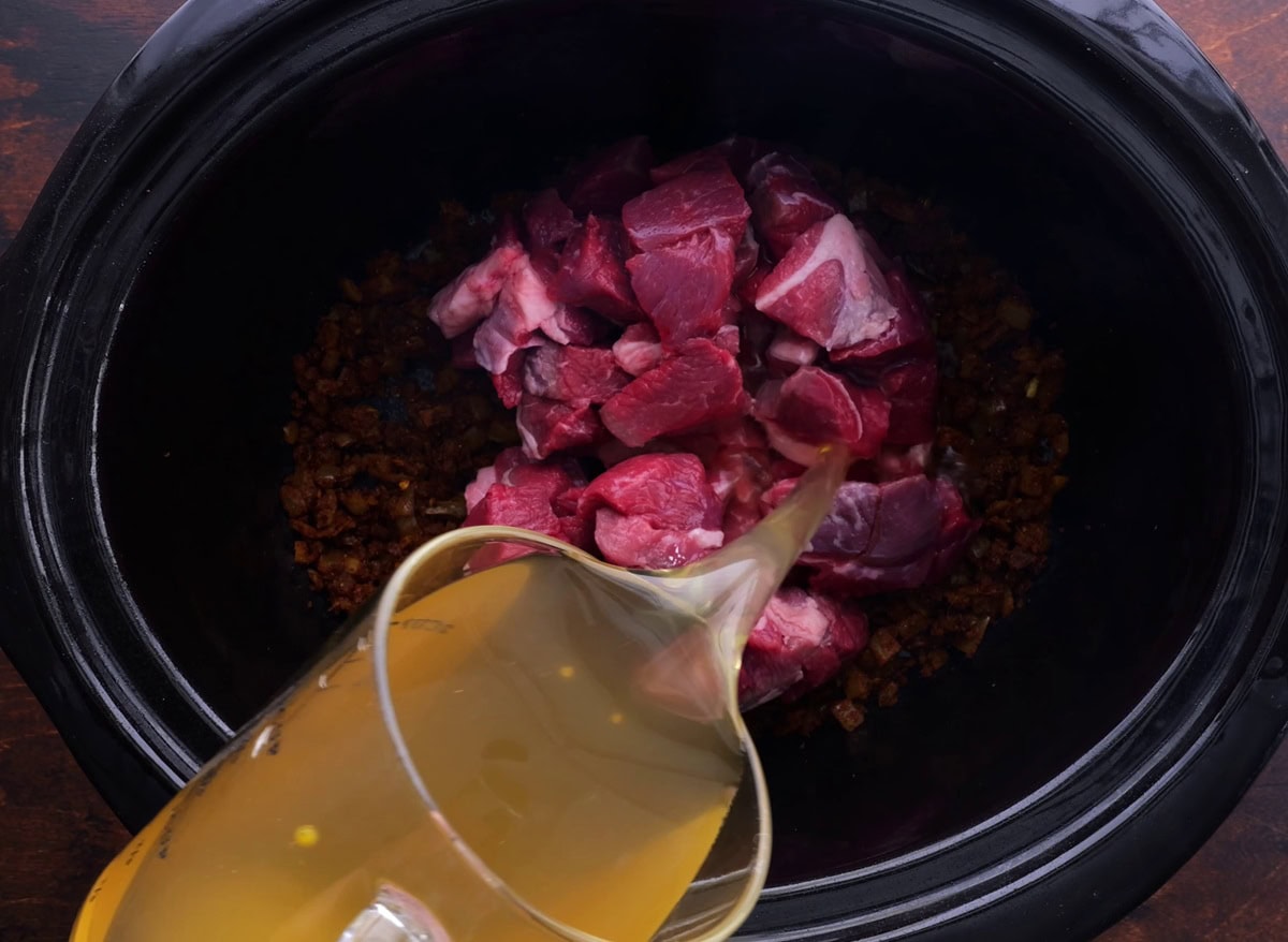 Pouring chicken broth into the crock pot.