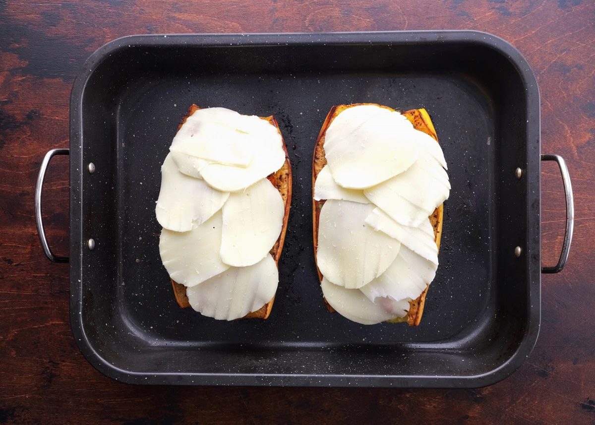 Spaghetti squash stuffed with red sauce and covered with mozzarella cheese, ready to go into the oven.