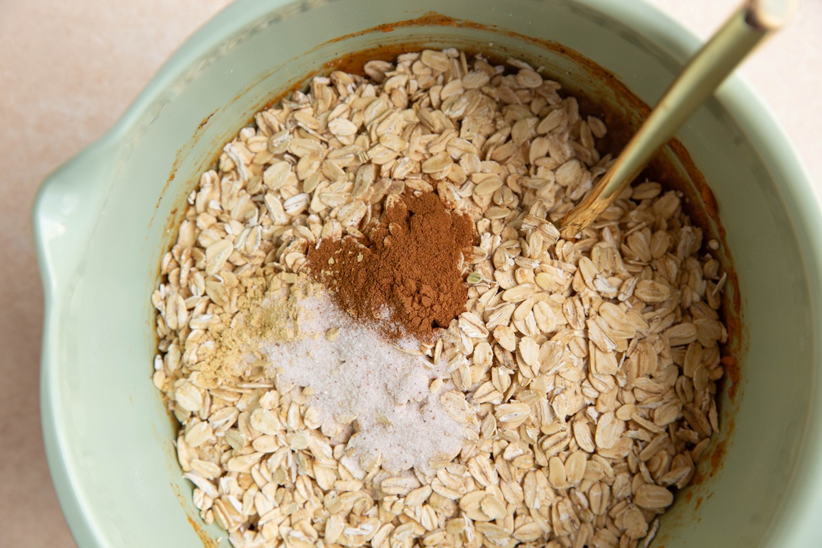 Oats in a mixing bowl with sweet potato mixture, cinnamon, and salt.