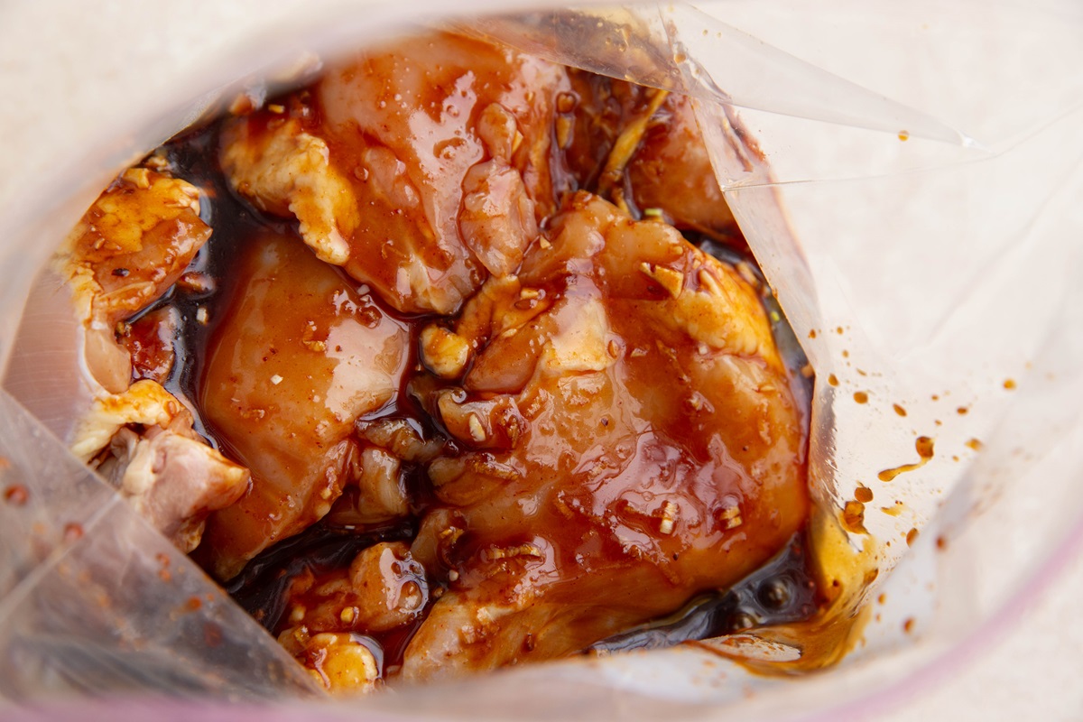 Zip lock bag full of chicken thighs and Korean sauce marinade to be marinated for BBQ chicken.