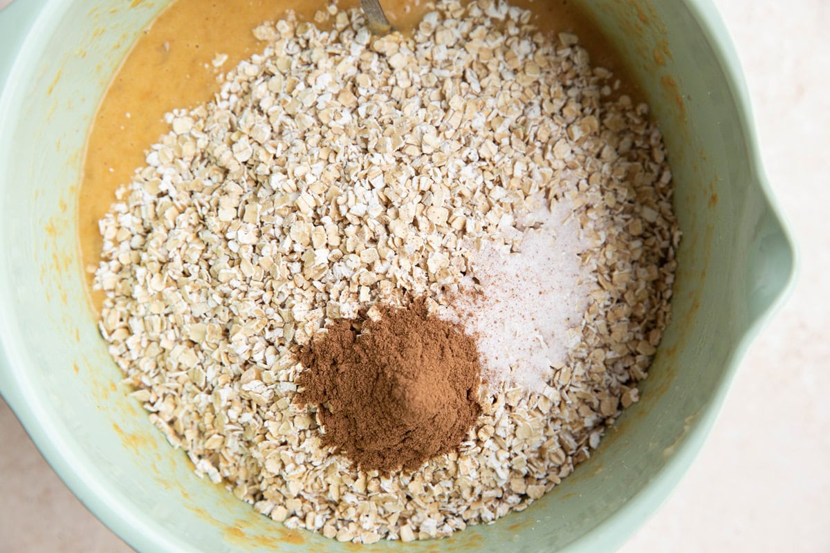 Dry ingredients on top of wet ingredients in a mixing bowl to make banana baked oatmeal muffins