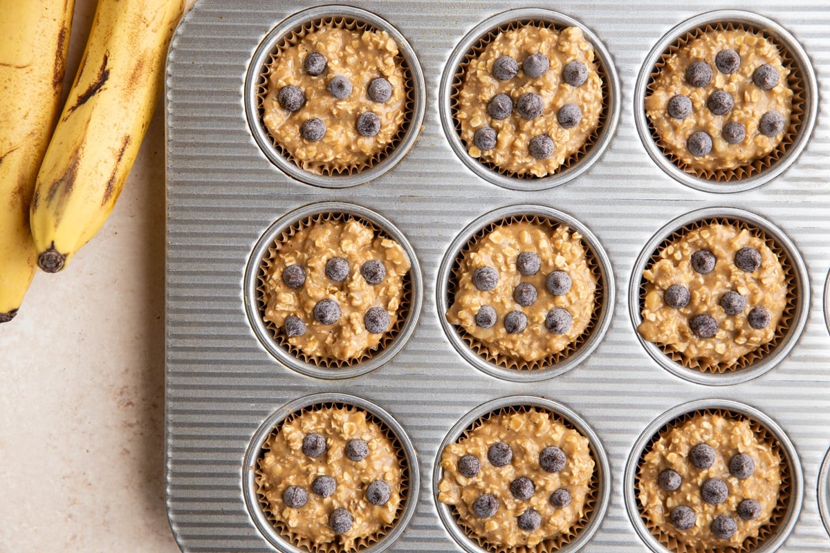 banana baked oatmeal muffin batter in a muffin tray, ready to be baked.