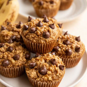 Plate of banana oatmeal muffins with a plate of muffins in the background.