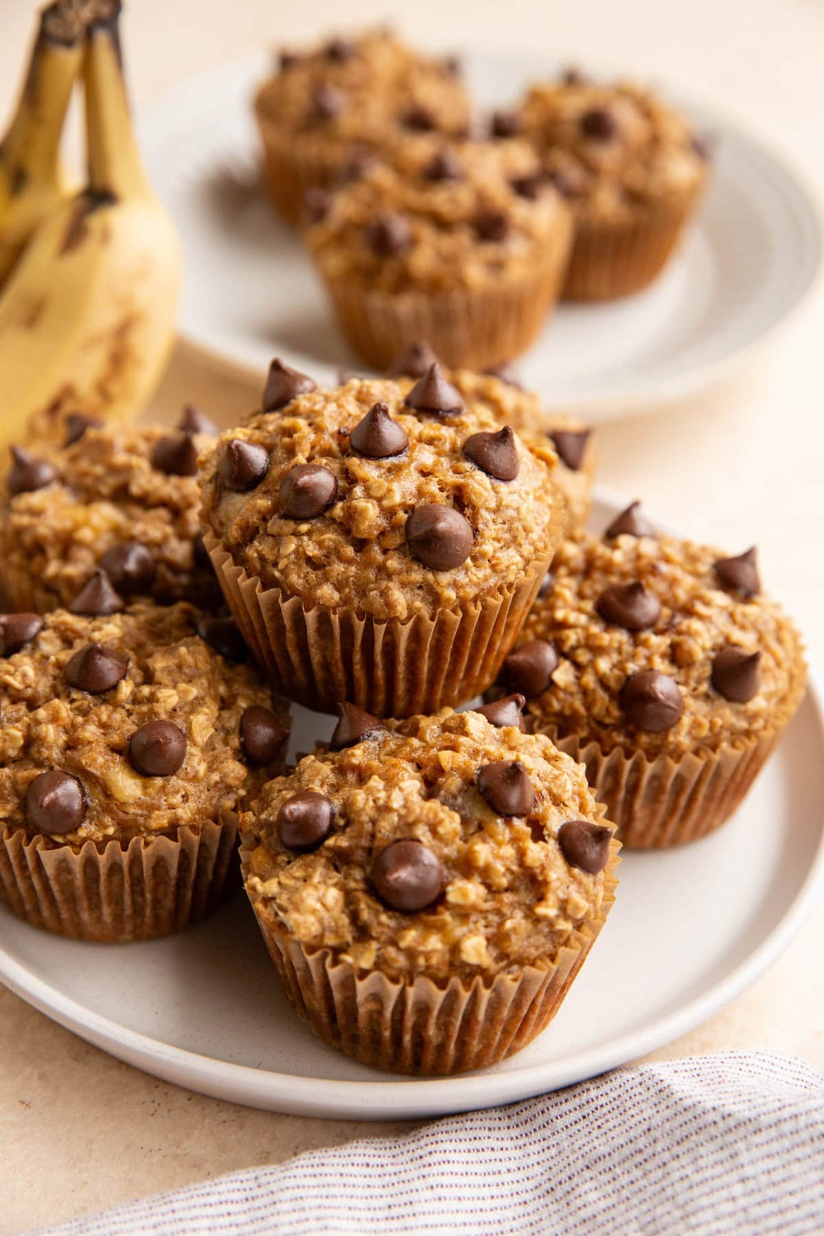 Plate of banana oatmeal muffins with a plate of muffins in the background.