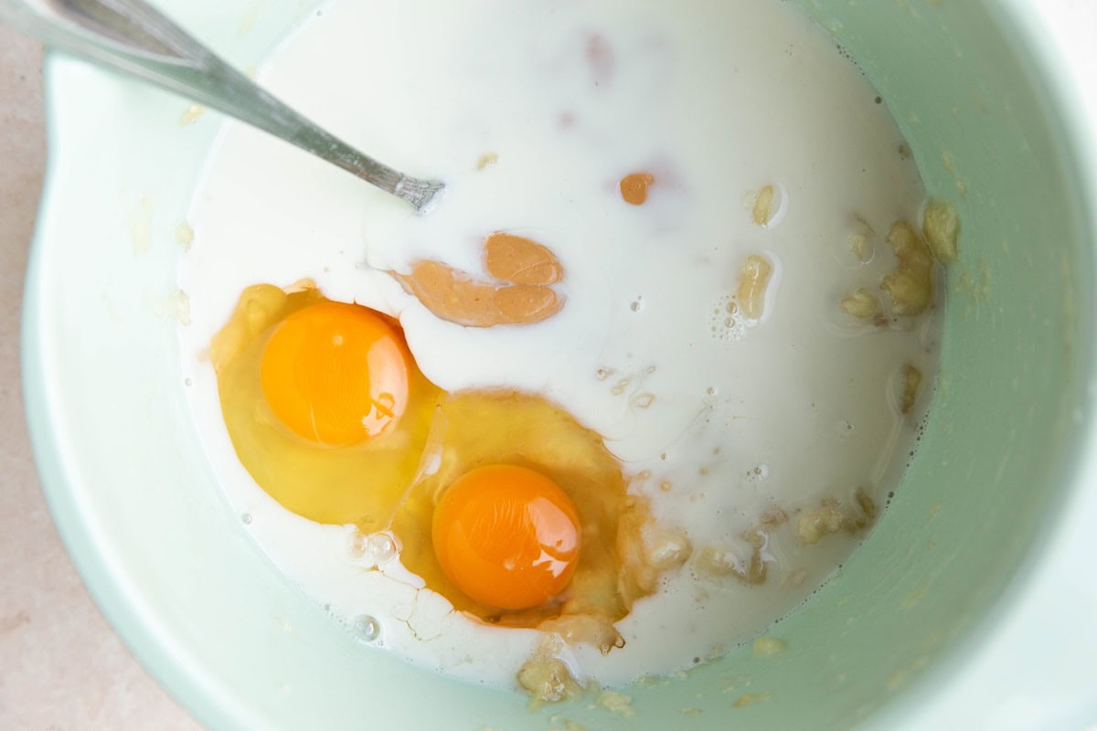 Wet ingredients for banana oatmeal muffins in a mixing bowl.