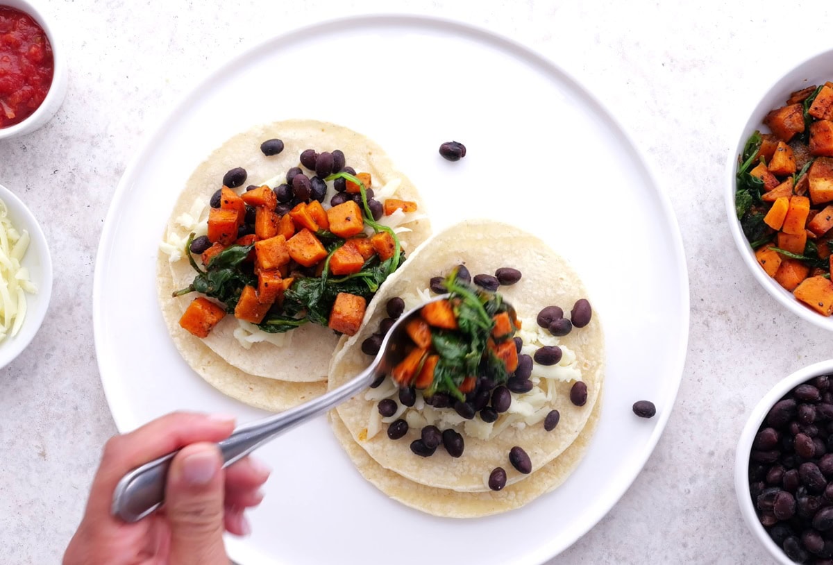 Hand assembling breakfast tacos.