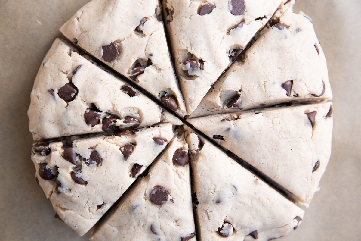 Scone dough cut into triangles to make individual scones.