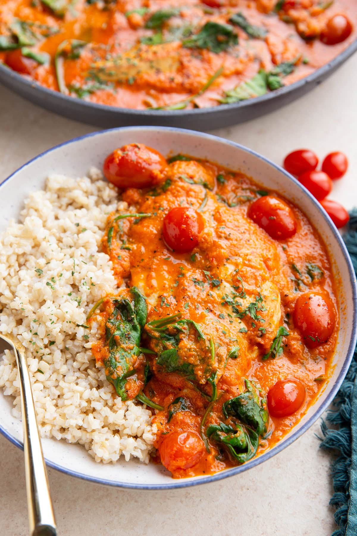 Bowl full of creamy red bell pepper chicken with rice.