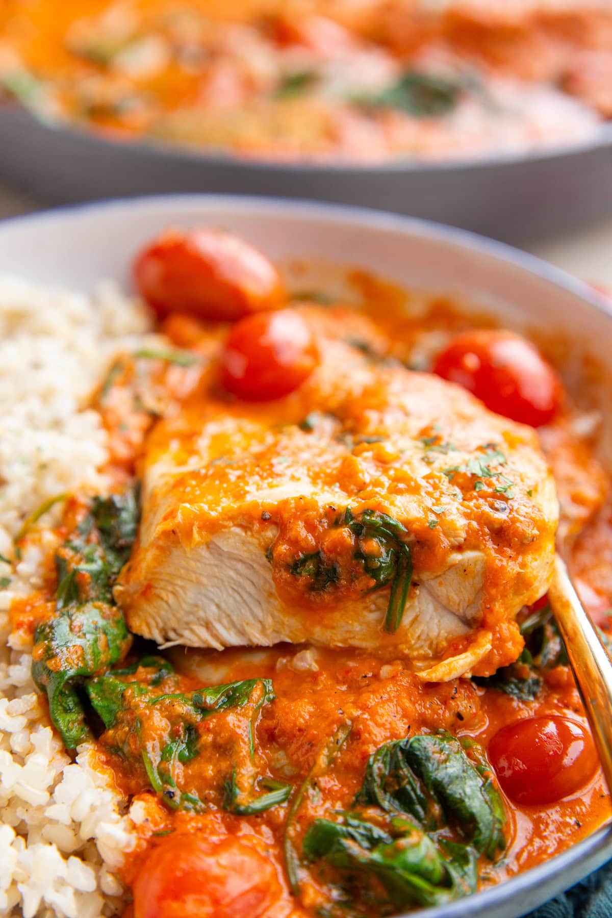 Chicken breast in red pepper sauce cut open to see the inside.