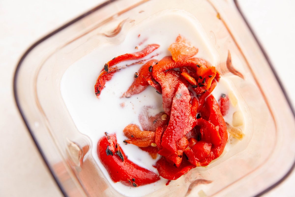Ingredients for roasted red pepper sauce in a blender.