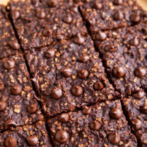 Breakfast bars on a sheet of parchment paper, cut into squares, ready to eat.