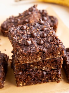 Stack of chocolate oatmeal breakfast bars with more bars in the background.