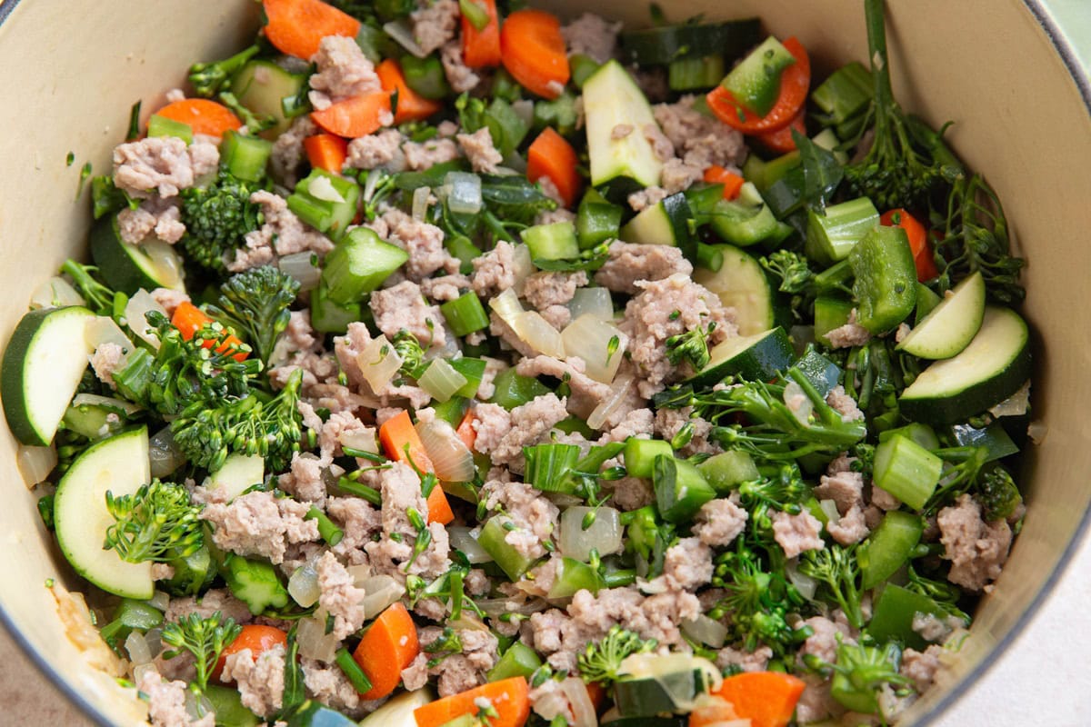 Vegetables and ground turkey cooking in a soup pot.