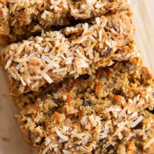 Sliced carrot cake bread on a sheet of parchment paper, ready to serve.