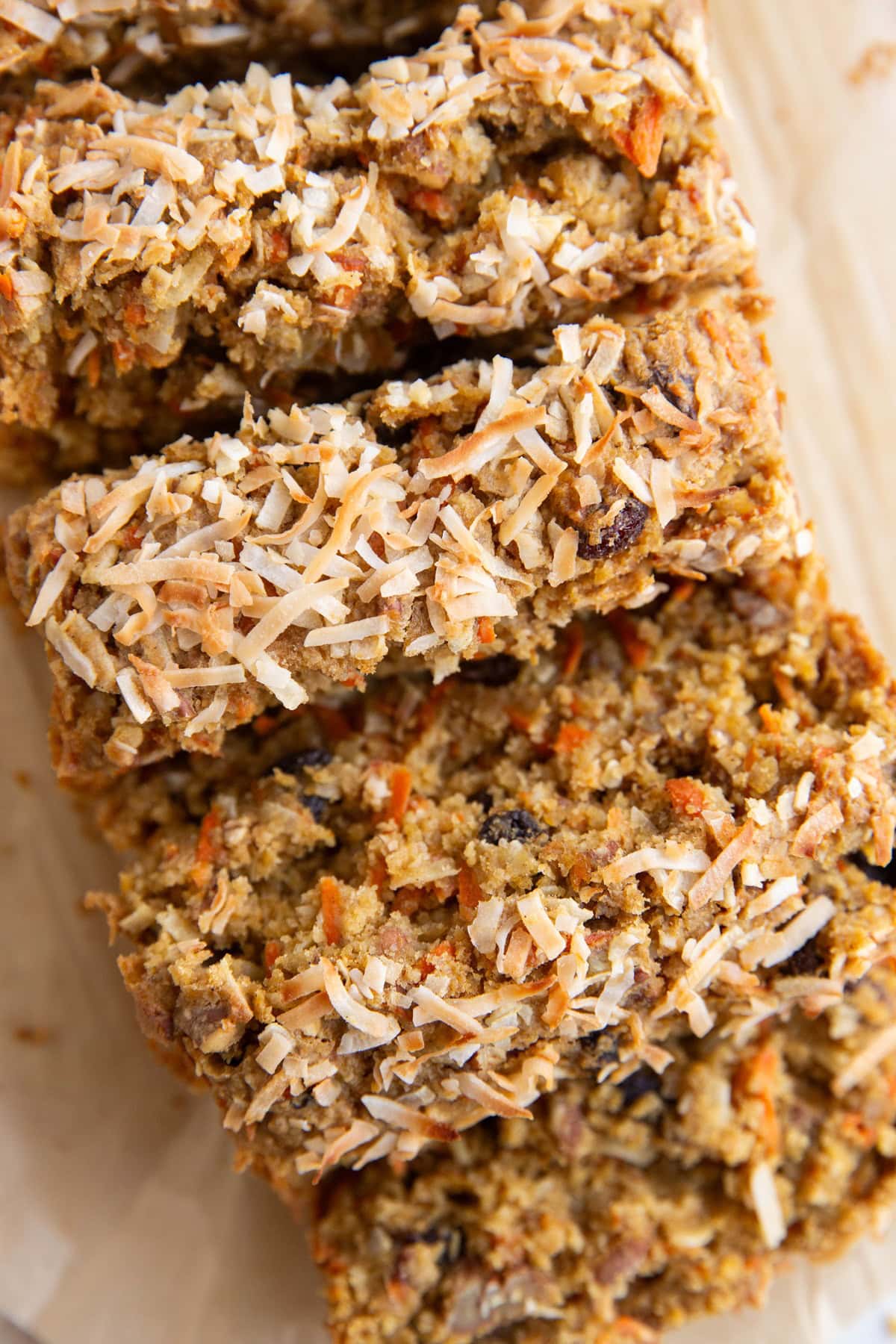 Sliced carrot cake bread on a sheet of parchment paper, ready to serve.