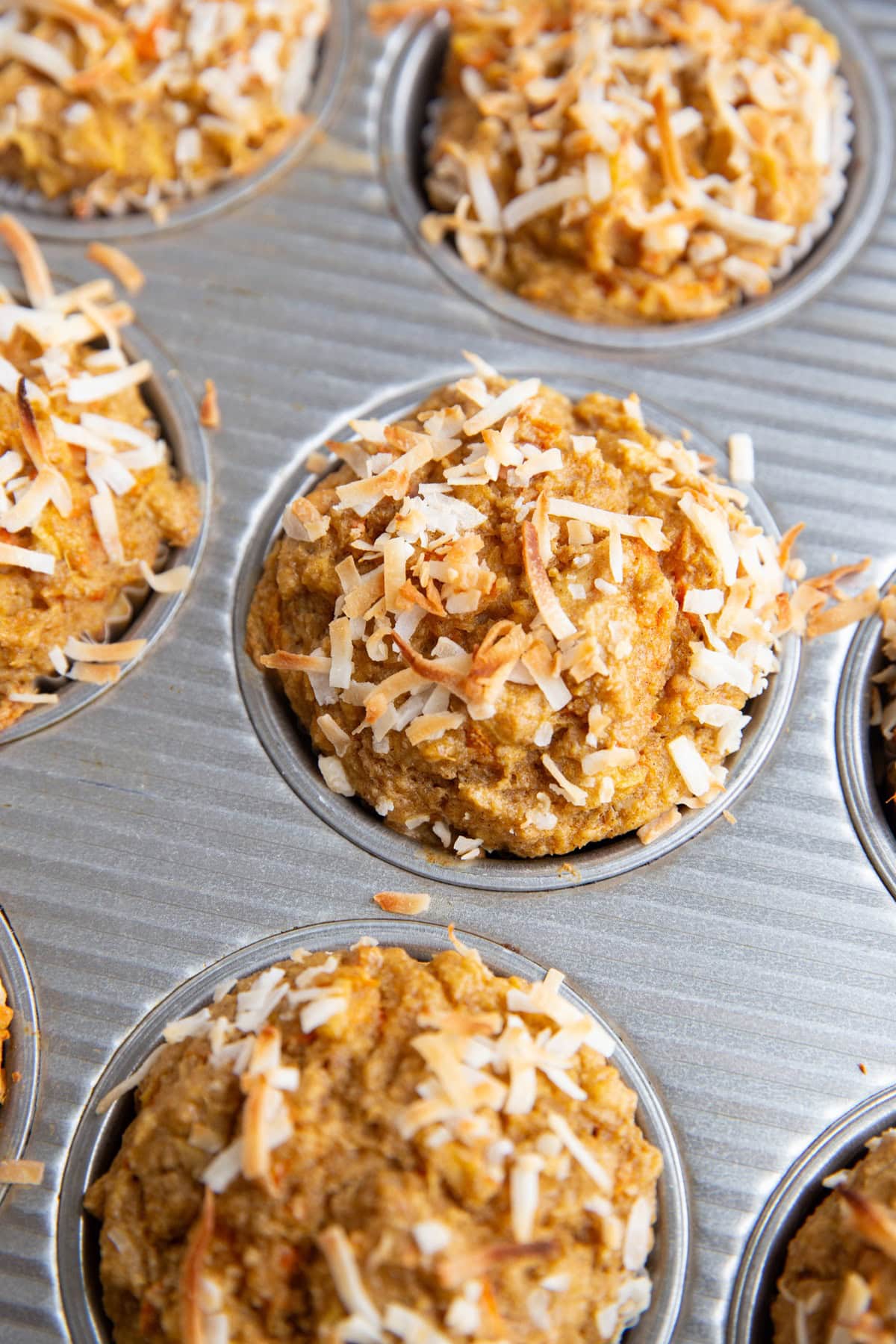 Muffin tin with baked carrot muffins inside, fresh out of the oven.