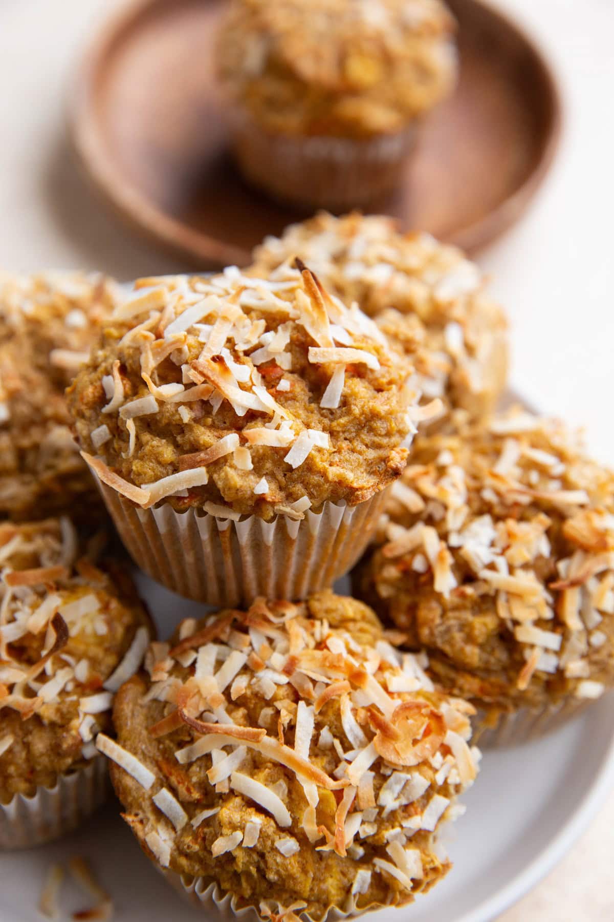 Stack of carrot muffins on a white plate, ready to eat.