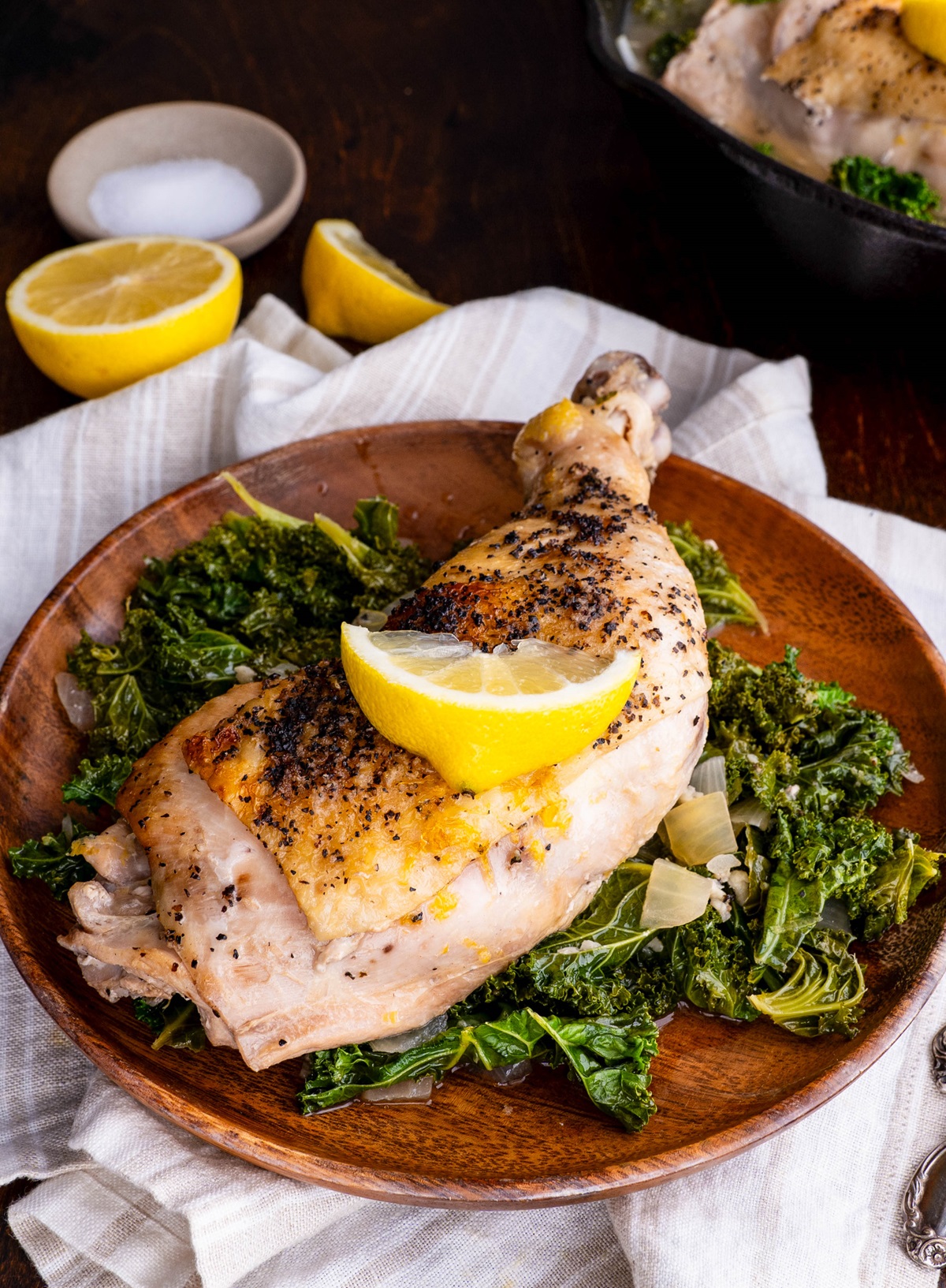 Braised chicken leg on a plate with kale
