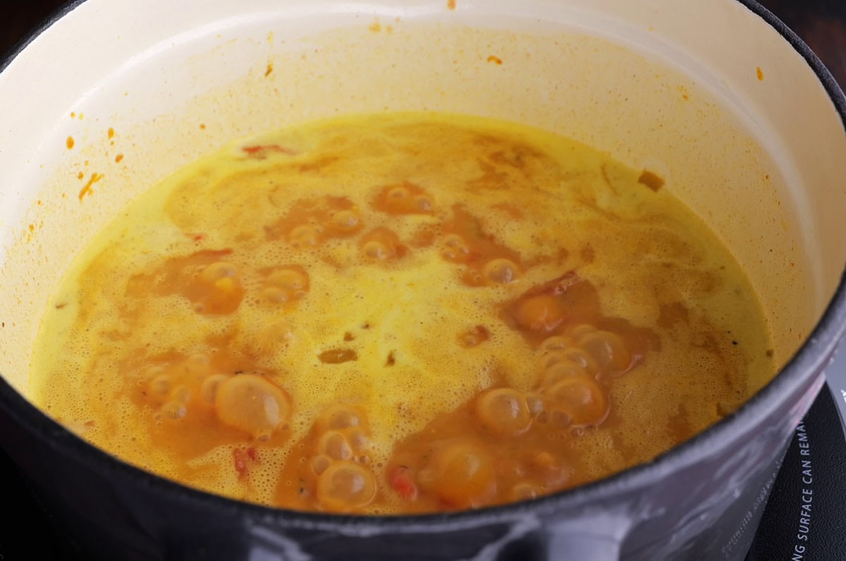 Coconut curry sauce boiling on the stove top.