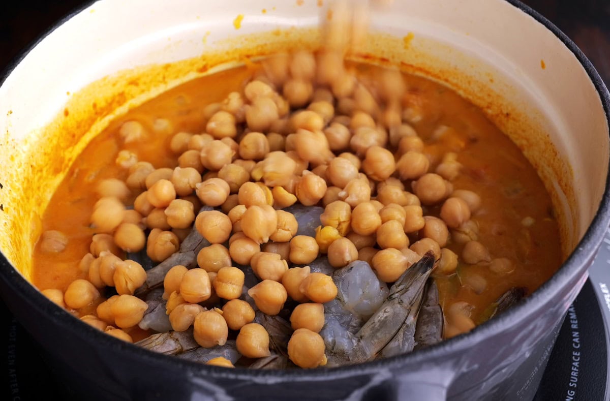 Raw shrimp and chickpeas added into the curry sauce.