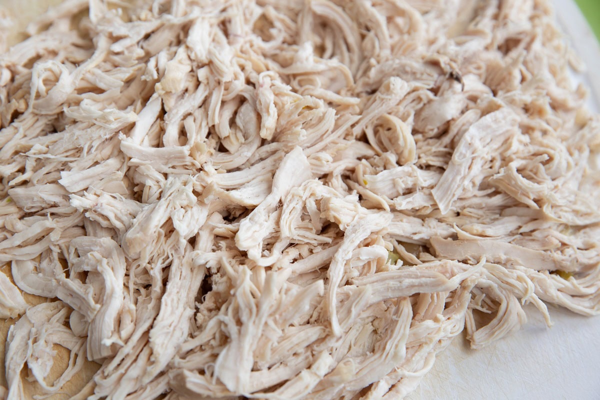 Shredded chicken on a cutting board.