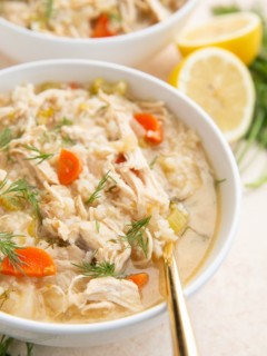 Two white bowls of shredded chicken soup