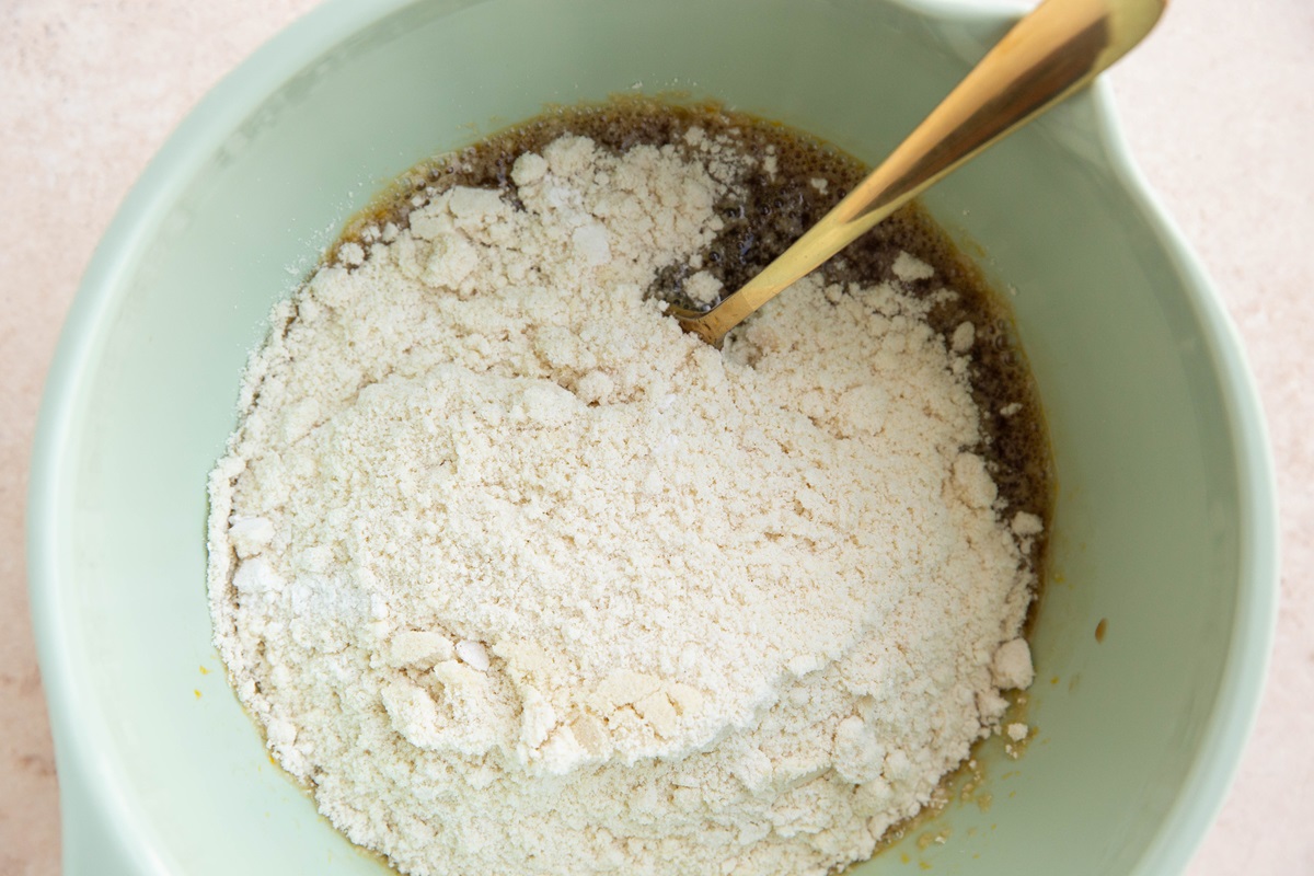 Mixing bowl with wet ingredients and dry ingredients ready to be mixed for quick bread.